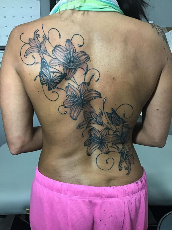 Full backpiece tattoo with lilies, filagree and butterflies 